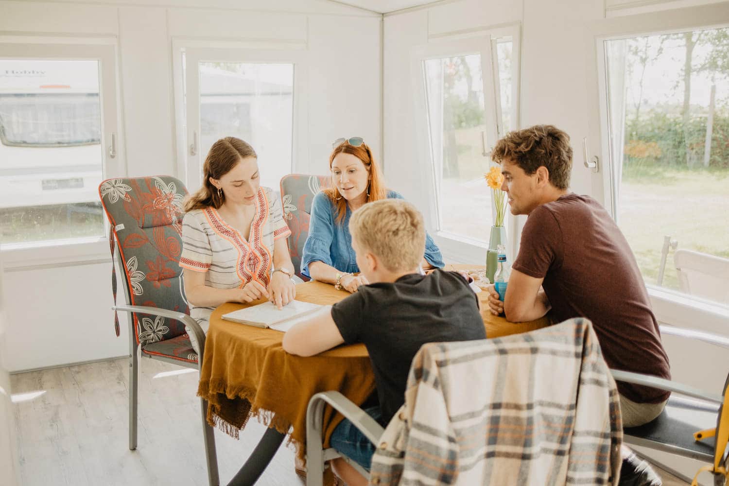 Familie am Esstisch im Mietwohnwagen