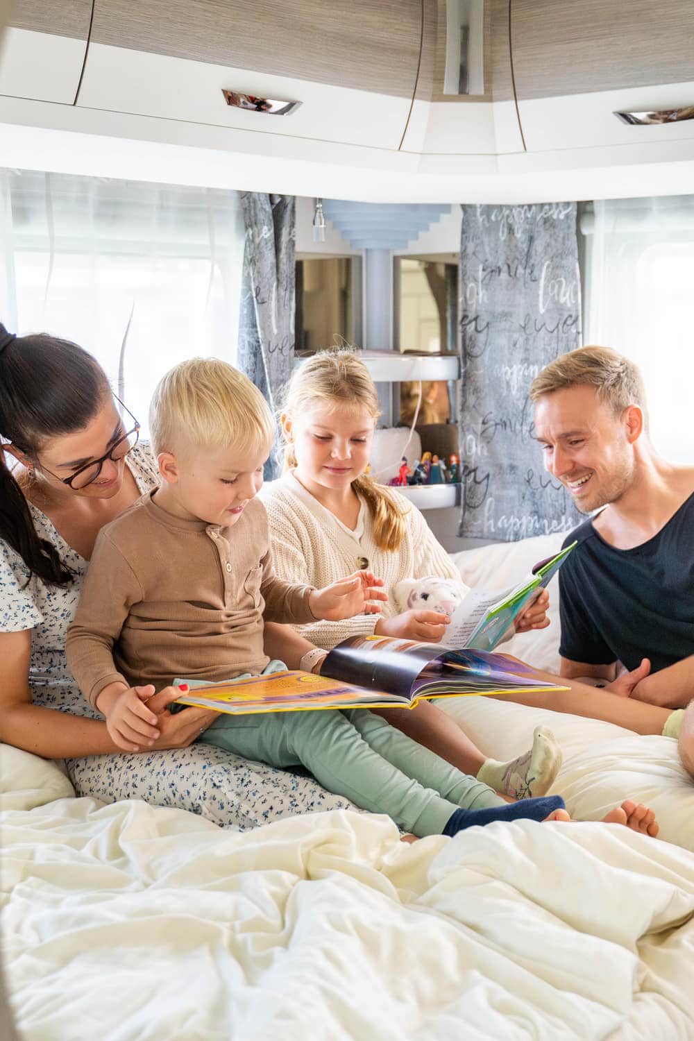 Familie liest gemeinsam im Mietwohnwagen