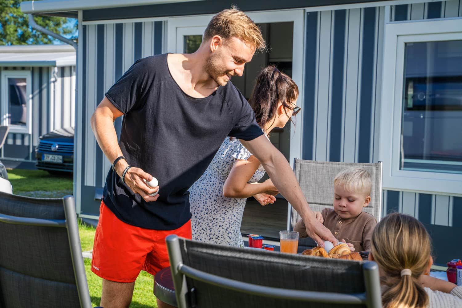 Familie beim Frühstück vor dem Mietwohnwagen