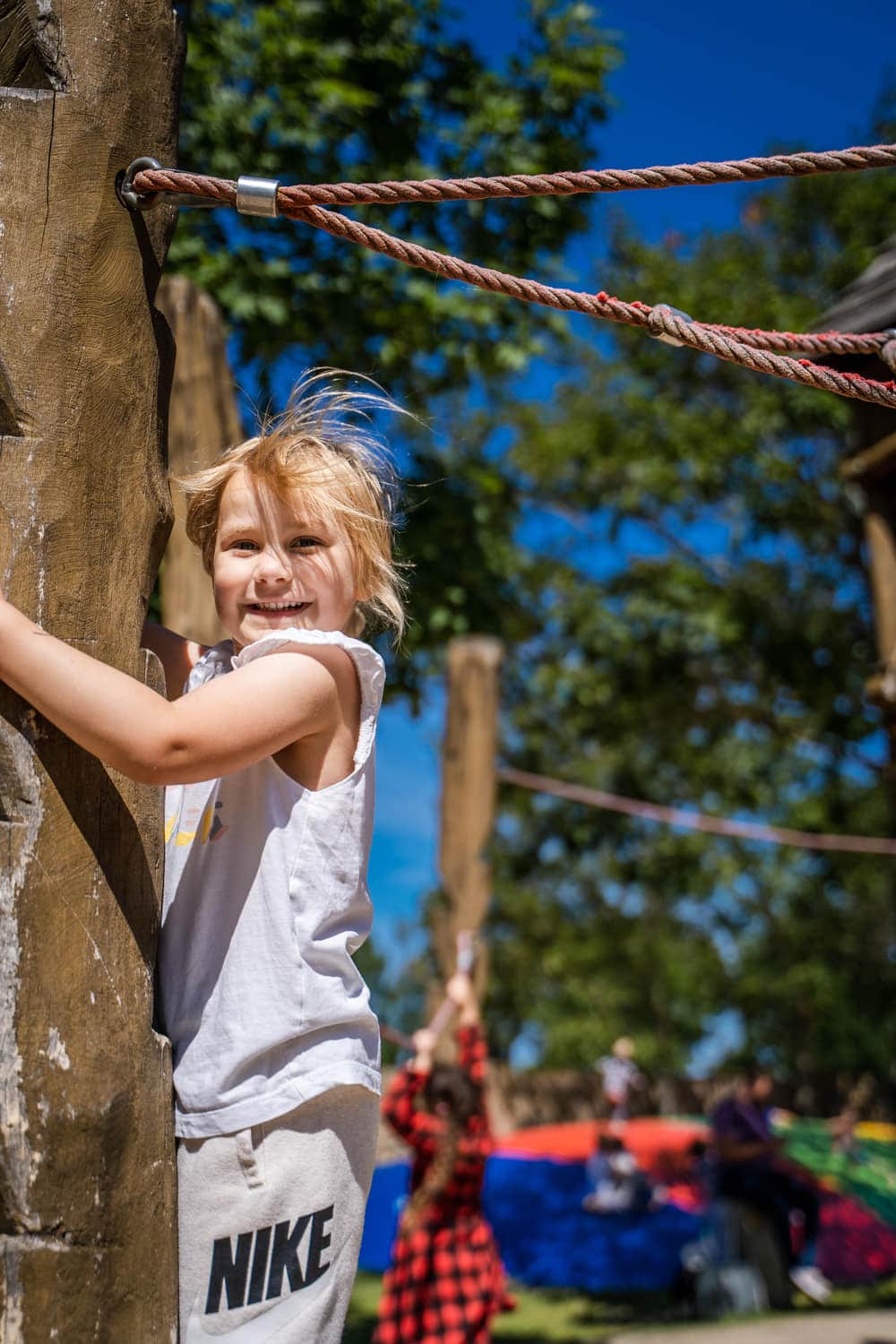 Kind klettert im Niedrigseilgarten