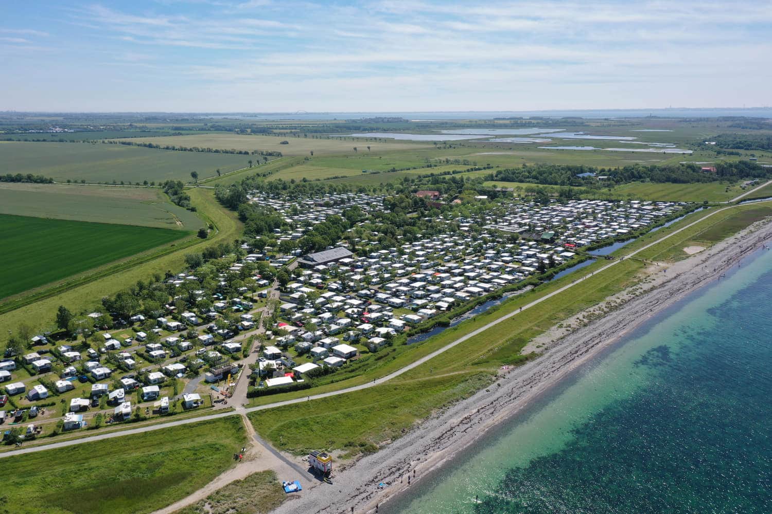 Luftbild von Deich, Strand und Campingplatz