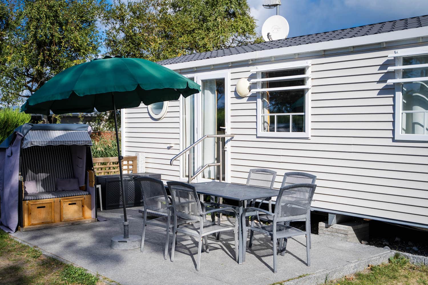 Terrasse eines Mobilheims mit Sonnenschirm