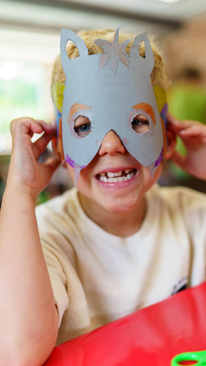 Kind mit selbst gebastelter Maske