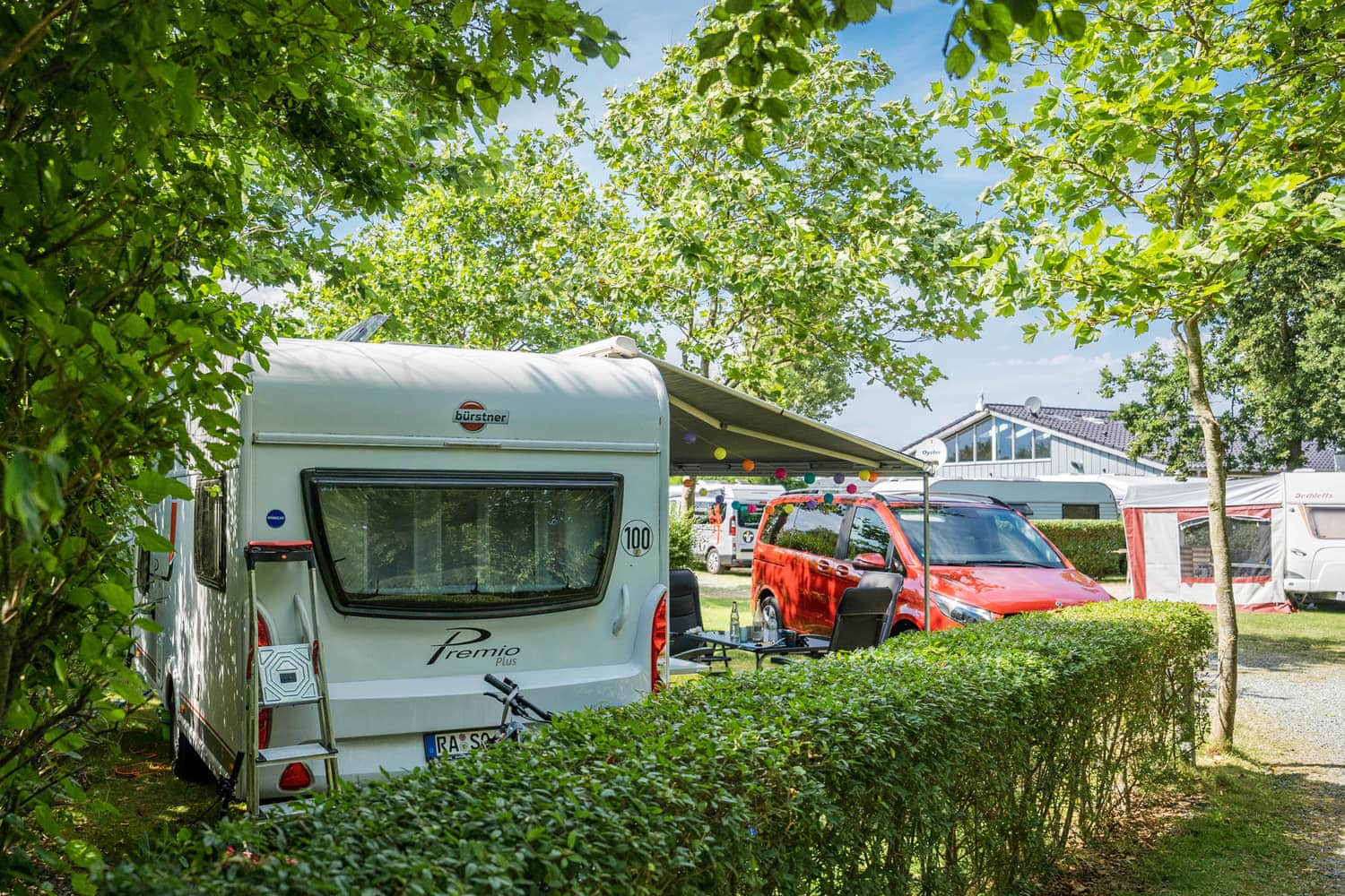 Stellplatz mit Hecke und Wohnwagen