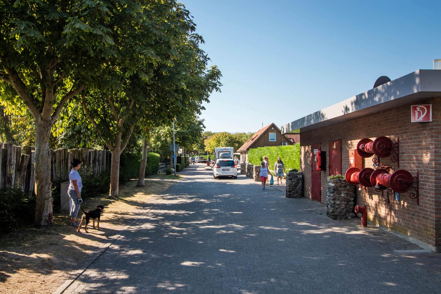 Weg über den Platz an den Wirtschaftsgebäuden vorbei