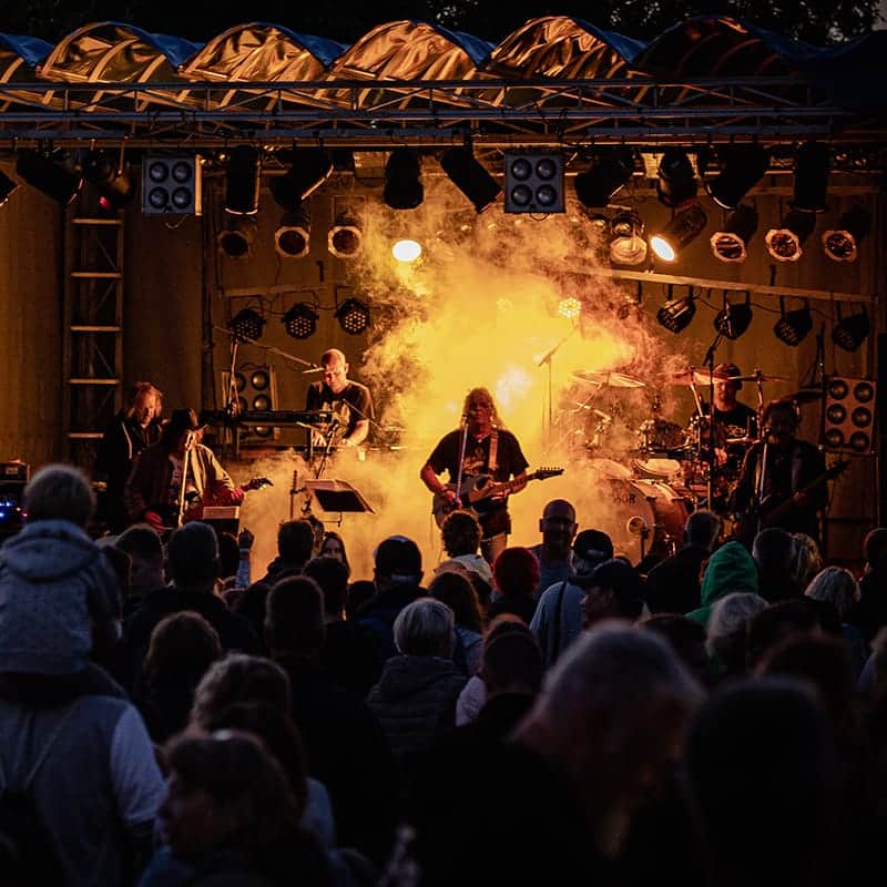 Band op het podium voor publiek tijdens een avondconcert