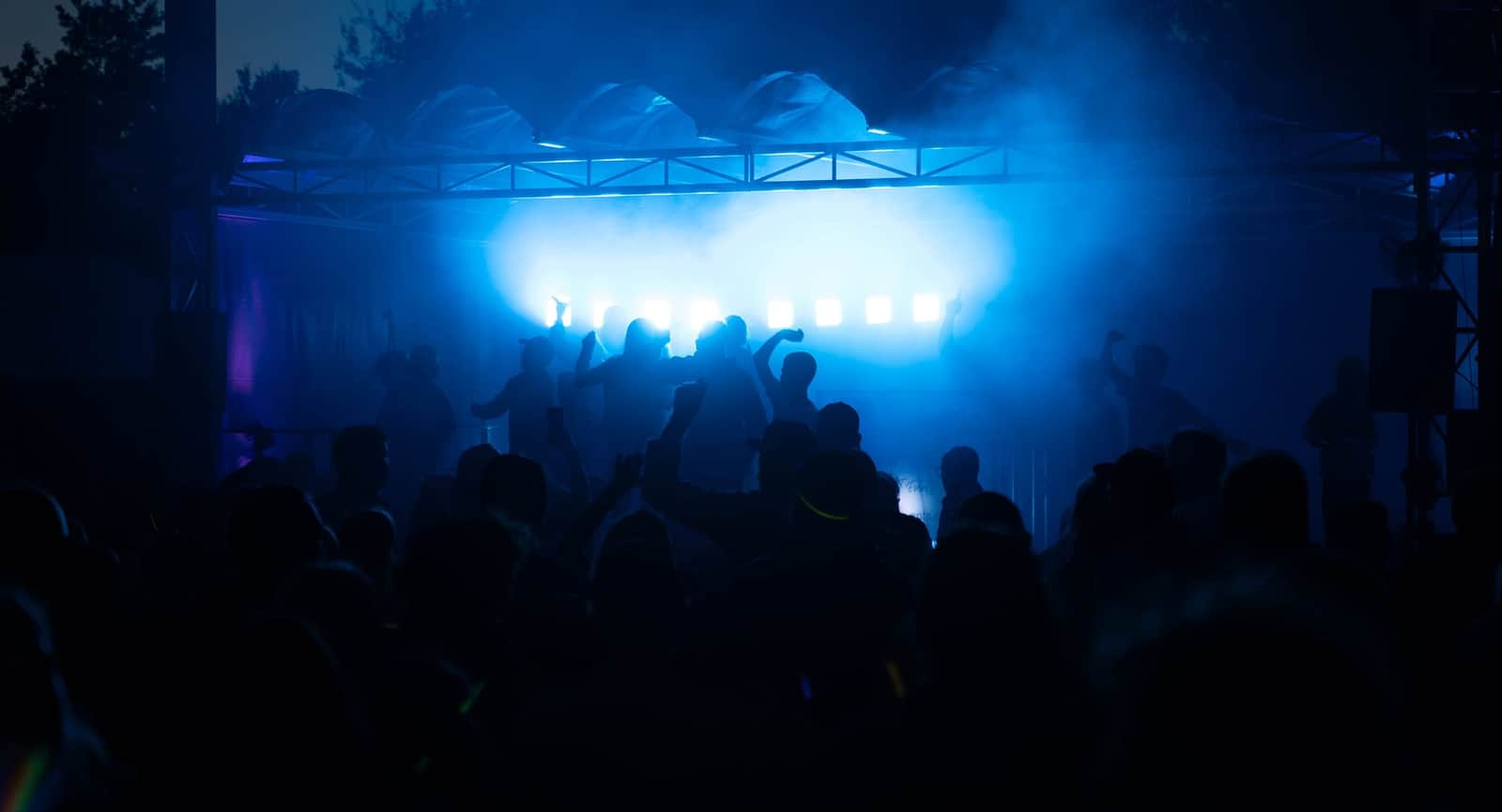 Gasten dansen in blauwe spots tijdens het sunsetfeest