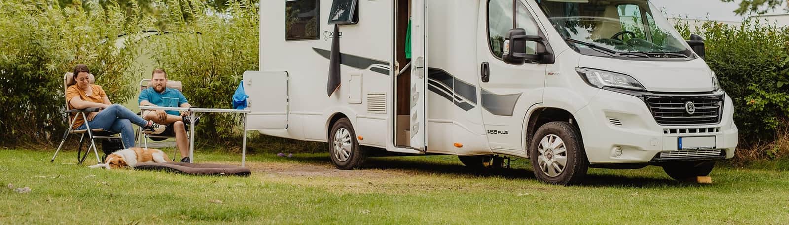 Caravan met voortent op een door hagen omzoomde plaats in het groen