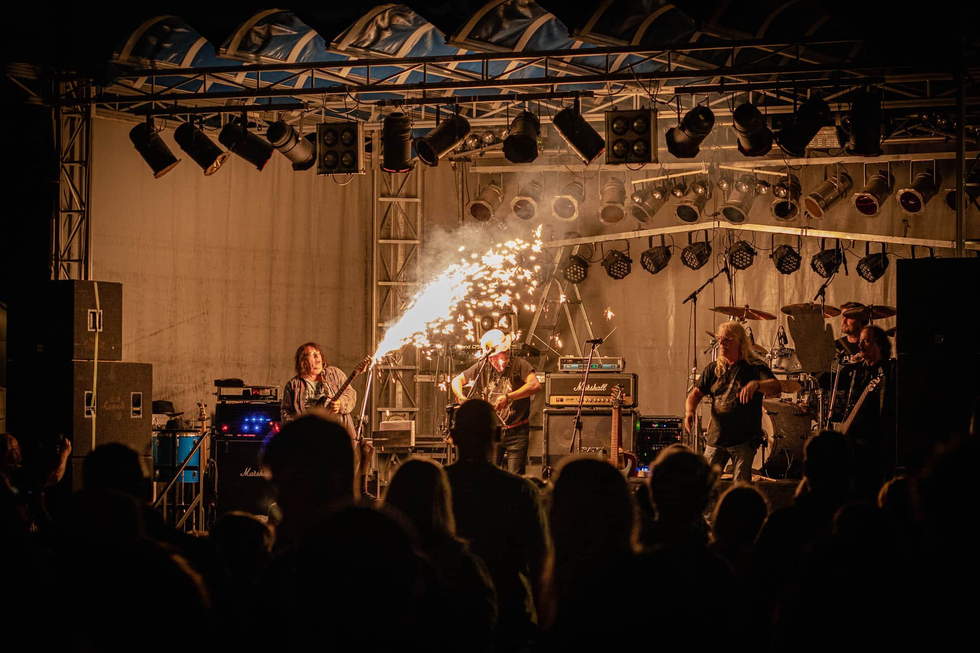 Band auf der Bühne beim Abendkonzert, Funkenfontäne über den Köpfen des Publikums