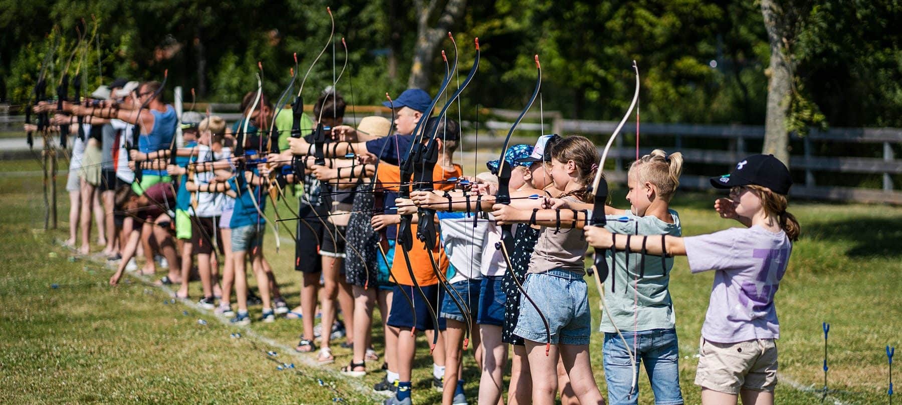 Gruppe beim Bogenschießen auf der Sportwiese