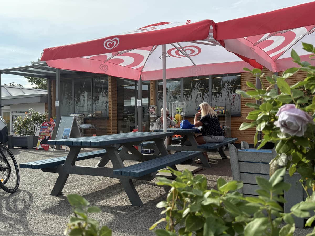 Bänke und Sonnenschirme auf der Terrasse vor dem Strandmarkt