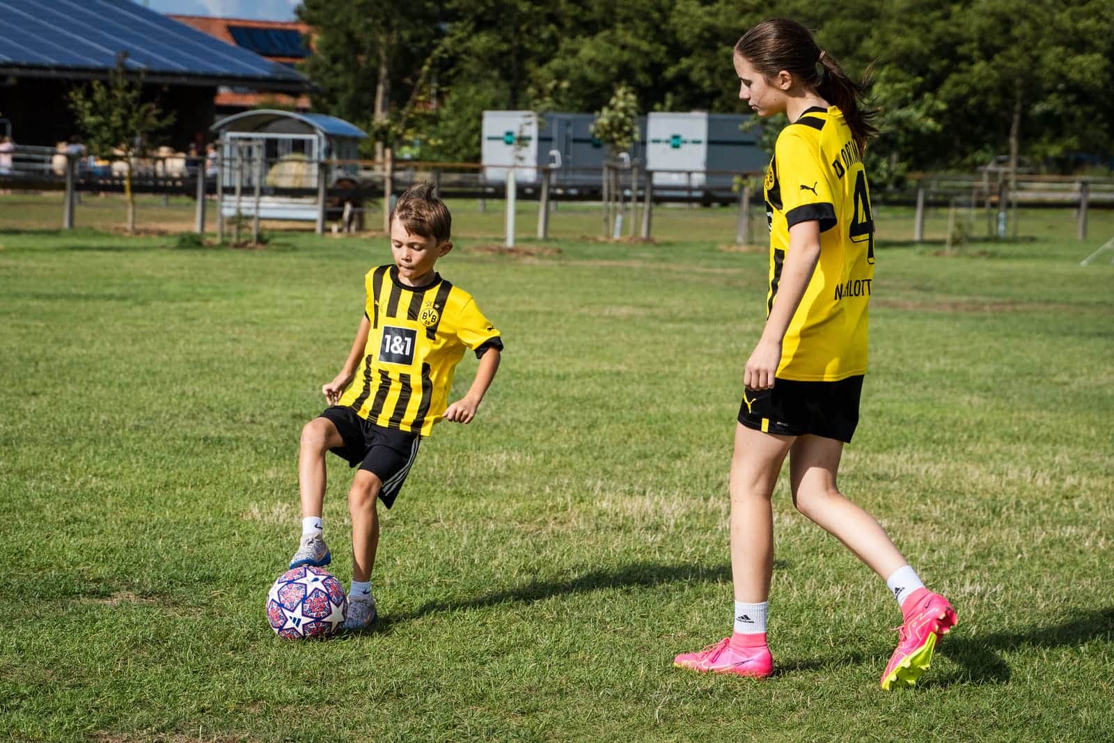 Zwei Kinder im Trikot beim Fußball auf dem Sportplatz