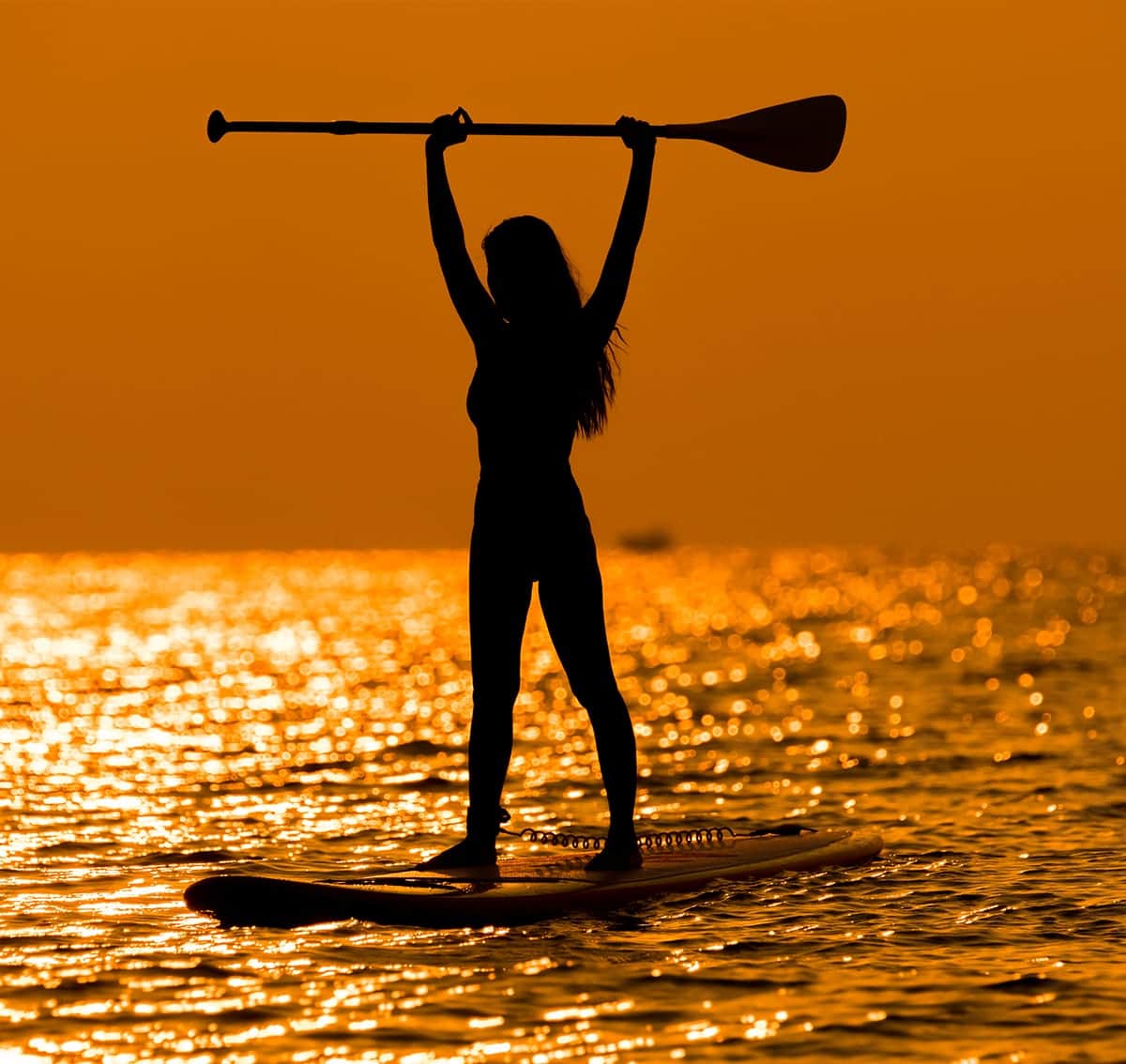 Stand-Up-Paddlerin im Gegenlicht auf der Ostsee
