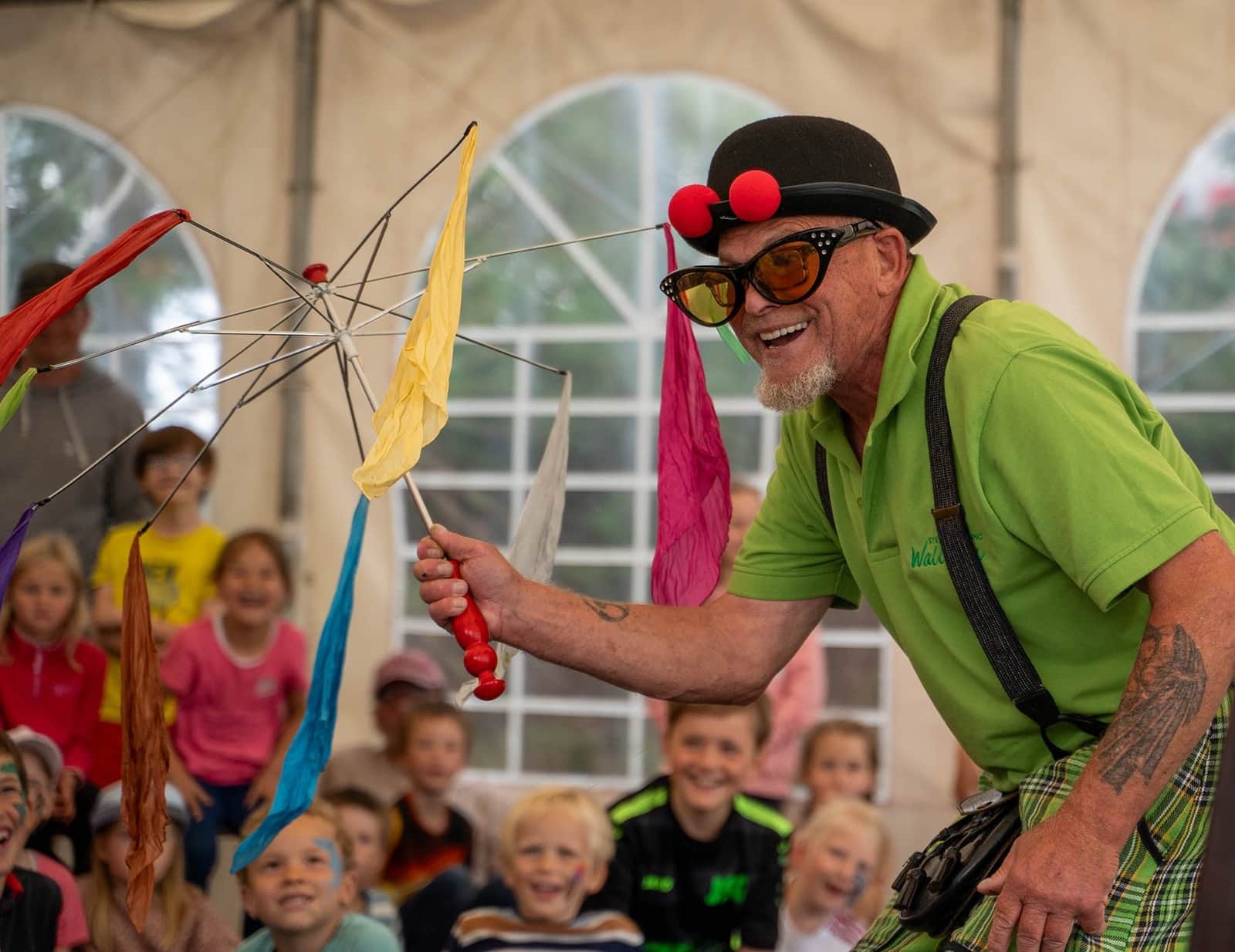Magician entertaining a group of children in the marquee